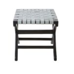 Teak wood stool with woven grey leather straps and black-stained scrolled legs, blending boho style with natural sophistication.