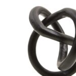 Matte black twisted knot sculpture on a raw-edged white marble base.