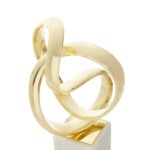 Gold knot sculpture on white marble base – elegant contemporary décor accent.