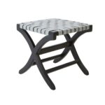 Teak wood stool with woven grey leather straps and black-stained scrolled legs, blending boho style with natural sophistication.