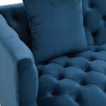 Two-seat navy fabric Chesterfield-style sofa with button tufting and gold-accented wooden legs.