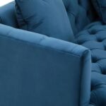 Two-seat navy fabric Chesterfield-style sofa with button tufting and gold-accented wooden legs.