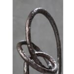 Round rough bronze abstract aluminium sculpture with circular base.