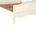 White carved wooden bed with upholstered buttoned panels, featuring a rustic weathered finish and bohemian French-inspired design.