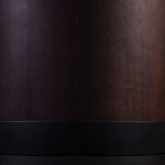 JOBURG 150 Dining Table with round smoked eucalyptus veneer top and black cylindrical steel base – Ø150 cm luxury dining table for contemporary interiors.