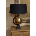VAULT Brass Globe Table Lamp with matte antique brass rotating globe, tiered square black pedestal base, and black fabric tapered shade.