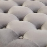 LUCRA Grey Velvet Footstool – round grey velvet footstool with button tufting and foam padding.