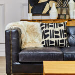Alt text: VURO Three Seat Black Leather Sofa in antique ebony leather with button tufted back, Chesterfield-inspired three-seat sofa with oak wood legs, elegant black leather sofa for modern and classic interiors.