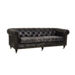 Alt text: IBERIA Three Seat Ebony Leather Sofa in Chesterfield design with deep button tufting, rolled arms, and ebony leather upholstery, classic three-seat sofa with vintage castor feet.