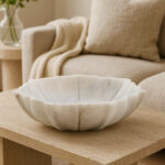 LOTUS Small White Marble Bowl with sculpted lotus-petal edges and polished finish displayed on a modern console table. LIFESTYLE IMAGE