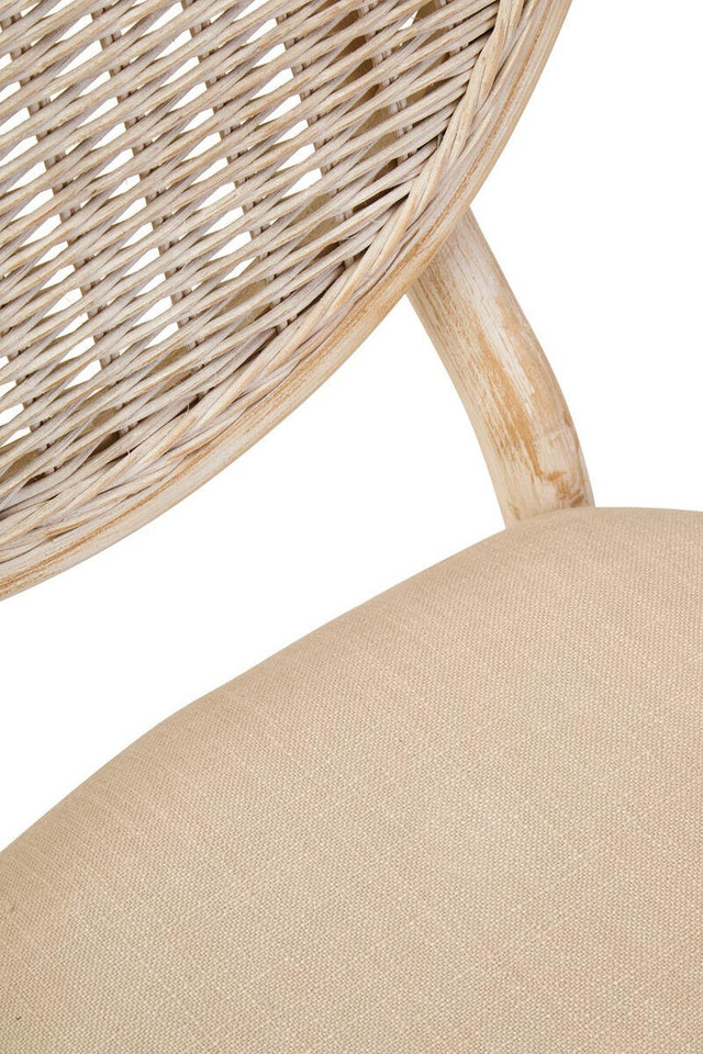 WALTON White Wash Elm Wood Dining Chair featuring cane woven backrest and beige cushioned seat styled in a bright modern dining room.