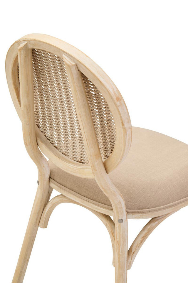 WALTON White Wash Elm Wood Dining Chair featuring cane woven backrest and beige cushioned seat styled in a bright modern dining room.