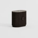 NOEL Ash & Marble Bedside Table with dark ash wood base and elegant grey marble top beside a modern bed.