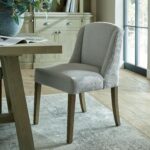 COMPTON Grey Dining Chair – Handcrafted grey twill dining chair with solid wood frame, curved backrest, and sloped armrests for exceptional comfort and style.