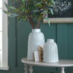 MONTE Large Bell Vase – Crystal-clear glass bell-shaped vase, ideal for contemporary floral arrangements or modern decorative displays. lifestyle image with green branches in