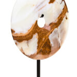 Polished round onyx disc in natural earthy tones displayed on a black metal stand.