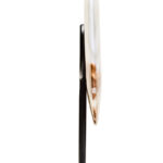 Polished round onyx disc in natural earthy tones displayed on a black metal stand.