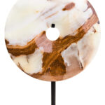 Polished round onyx disc in natural earthy tones displayed on a black metal stand.