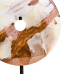 Polished round onyx disc in natural earthy tones displayed on a black metal stand.