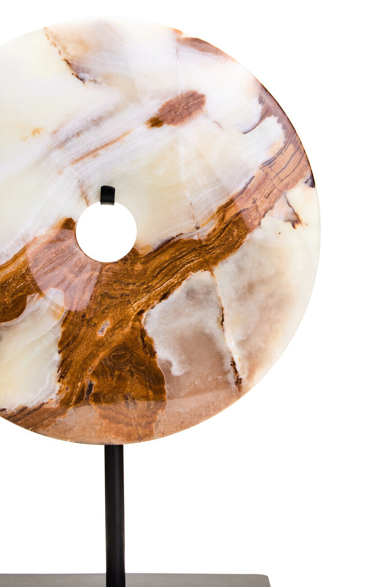 Polished round onyx disc in natural earthy tones displayed on a black metal stand.