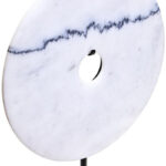 The ZORO Medium White Marble Disc Sculpture features a polished white marble disc with natural veining mounted on a sleek black metal stand, offering a refined and minimalist decorative accent.