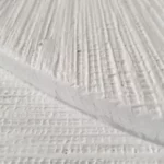 White textured wall art with vertical ribbed detailing and a semi-circular relief in a wooden frame.