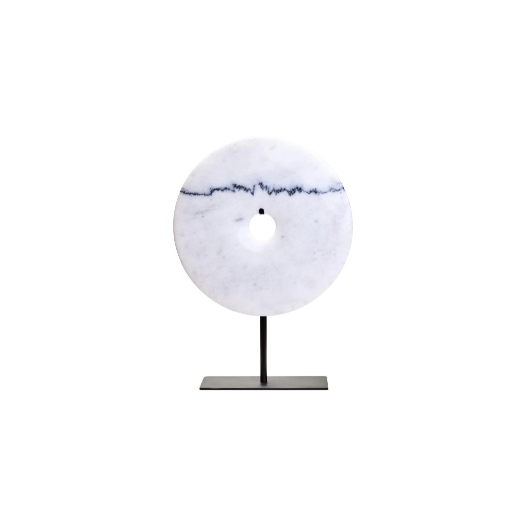 The ZORO Medium White Marble Disc Sculpture features a polished white marble disc with natural veining mounted on a sleek black metal stand, offering a refined and minimalist decorative accent.