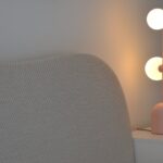 WAVE bed in natural weave fabric with curved upholstered headboard and round wooden legs in neutral modern bedroom.