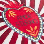 Amor velvet piped cushion in red with bold Mexican inspired pattern and feather filling.