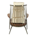 Brown genuine leather quilted chair with iron frame and curved wooden armrests, designed for industrial-style modern interior seating.