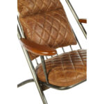 Light brown quilted leather chair with iron frame and wooden armrests, designed for industrial-style modern interior seating.