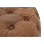 Round tufted leather ottoman in vintage brown with button detailing and cushioned top, designed for classic and rustic interior seating.