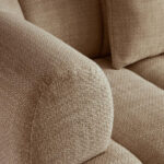 Cream linen curved three seater sofa with channel tufted detailing and rounded back design for modern luxury living room seating.