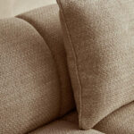 Cream linen curved three seater sofa with channel tufted detailing and rounded back design for modern luxury living room seating.